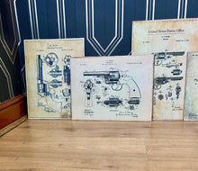 Load image into Gallery viewer, This collection features seven stunning vintage-style artworks of guns, revolvers, and shotguns. These prints, likely created in the 1990s, are displayed on old wooden sheets.