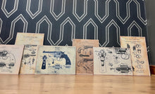 Load image into Gallery viewer, This collection features seven stunning vintage-style artworks of guns, revolvers, and shotguns. These prints, likely created in the 1990s, are displayed on old wooden sheets.