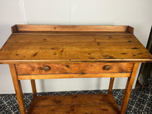 Load image into Gallery viewer, Excellent pitch pine clerk desk with raised back and sloped writing surface over a single fall-front cupboard with key, raised on square supports united by under-tier two plank pine shelf.