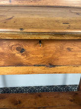 Load image into Gallery viewer, Excellent pitch pine clerk desk with raised back and sloped writing surface over a single fall-front cupboard with key, raised on square supports united by under-tier two plank pine shelf.