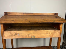 Load image into Gallery viewer, Excellent pitch pine clerk desk with raised back and sloped writing surface over a single fall-front cupboard with key, raised on square supports united by under-tier two plank pine shelf.