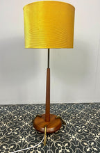 Load image into Gallery viewer, Vintage Scandinavian designer Teak Floor Lamp. This stunning teak floor lamp features a circular base with stylish brass details paired with a mustard fabric lamp shade. It is perfect as an additional light in your living room or workspace.