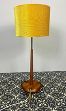 Load image into Gallery viewer, Vintage Scandinavian designer Teak Floor Lamp. This stunning teak floor lamp features a circular base with stylish brass details paired with a mustard fabric lamp shade. It is perfect as an additional light in your living room or workspace.