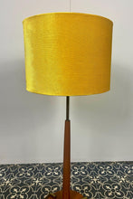 Load image into Gallery viewer, Vintage Scandinavian designer Teak Floor Lamp. This stunning teak floor lamp features a circular base with stylish brass details paired with a mustard fabric lamp shade. It is perfect as an additional light in your living room or workspace.