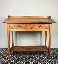 Load image into Gallery viewer, Excellent pitch pine clerk desk with raised back and sloped writing surface over a single fall-front cupboard with key, raised on square supports united by under-tier two plank pine shelf.
