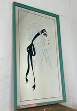 Load image into Gallery viewer, A collectible advertising piece featuring a glamorous lady in a vintage-style scarf bandana with her ribbon flowing down, posing thoughtfully. The mirror has a stylish feel and a noir finish with hint if colour. It is an excellent wall art piece to add a nice touch to your home.