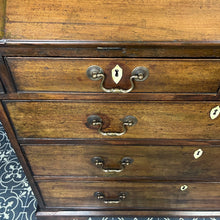 Load image into Gallery viewer, The antique mahogany bureau has a fall front that opens to reveal a writing surface. Its elegant fitted interior consists of six pigeon holes, five drawers on either side, and a central cupboard with Roman columns with a gold detail sitting on desirable runners
