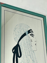 Load image into Gallery viewer, A collectible advertising piece featuring a glamorous lady in a vintage-style scarf bandana with her ribbon flowing down, posing thoughtfully. The mirror has a stylish feel and a noir finish with hint if colour. It is an excellent wall art piece to add a nice touch to your home.