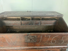Load image into Gallery viewer, Constructed from rich dark oak, it features a plain, authentic craftsmanship design supported by chunky tapered legs. The hinged lid features excellent dark iron pads with a striking bolt finish. The interior includes a drawer panel that opens to reveal two hidden drawers that slide across, adding a touch of period charm