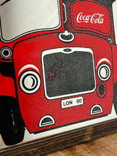 Load image into Gallery viewer, The mirror prominently features a red London double-decker bus with TRAFALGAR SQUARE and 12 on its destination sign, and Coca-Cola branding on the side of the bus. The license plate reads LON 80.