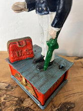 Load image into Gallery viewer, This mechanical coin bank features Uncle Sam, the national personification of the U.S. government. It is made of cast iron and hand-painted. When a coin is placed in Uncle Sam's hand and a lever is pressed, his arm moves down, depositing the coin into a bag and then into the bank's base; his beard also moves.
