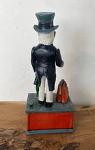 Load image into Gallery viewer, This mechanical coin bank features Uncle Sam, the national personification of the U.S. government. It is made of cast iron and hand-painted. When a coin is placed in Uncle Sam's hand and a lever is pressed, his arm moves down, depositing the coin into a bag and then into the bank's base; his beard also moves.