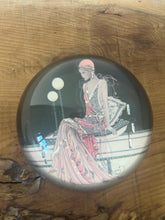 Load image into Gallery viewer, Beautiful vintage glass paperweight in Art Deco style, featuring an illustration of a lady in a pink dress and headpiece. This particular style, often associated with the roaring twenties, is characterised by its elegant and sophisticated portrayal of women, usually referred to as flapper ladies or Gatsby ladies.