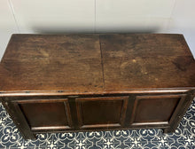 Load image into Gallery viewer, The antique oak coffer is of simple, plain form and has a hinged lid that opens to reveal a spacious interior. The coffer has a three-panel front and is raised on block feet. One of my favourite parts is the back panel that has been crudely chiselled from one section of oak, with an excellent, authentic craftsmanship finish.