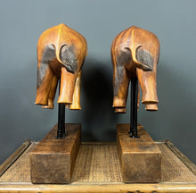 Load image into Gallery viewer, The elephants are carved from rosewood, with a two-tone finish that highlights the details of the skin and body. The carvings are detailed, showing the texture of the skin, the shape of the ears, and the tusks.