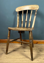 Load image into Gallery viewer, This style is a type of Windsor chair, a design that originated in England in the early 18th century and is characterised by its solid wooden seat into which the legs and spindles of the back are inserted.