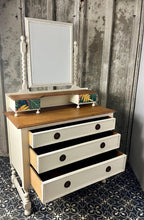 Load image into Gallery viewer, Beautiful vintage shabby chic dressing table with a stylish mirror and sleek drawers. This piece features a painted finish country cream with a contrasting natural wooden top, its distinctive floral patterned drawer fronts add a unique touch.