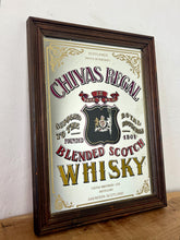 Load image into Gallery viewer, The mirror features vibrant, bold fonts in fabulous colours, with the royal crest in the middle and an intricate golden border. It is presented in a wooden frame and is in vintage condition, with a few signs of authentic patina.