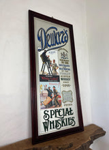 Load image into Gallery viewer, It includes a depiction of a seated Scotsman with a glass of whisky, and another scene below showing men with a cart, which are classic elements of Dewar's vintage advertising campaigns.