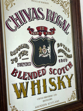 Load image into Gallery viewer, The mirror features vibrant, bold fonts in fabulous colours, with the royal crest in the middle and an intricate golden border. It is presented in a wooden frame and is in vintage condition, with a few signs of authentic patina.