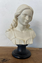 Load image into Gallery viewer, The figure depicts a young woman with wavy hair gathered into ringlets over her shoulders, wearing a draped garment with spaghetti straps and rosette detailing. Her facial expression is serene with downcast eyes.