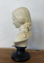 Load image into Gallery viewer, The figure depicts a young woman with wavy hair gathered into ringlets over her shoulders, wearing a draped garment with spaghetti straps and rosette detailing. Her facial expression is serene with downcast eyes.