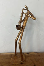 Load image into Gallery viewer, It features abstract, elongated figures of musicians playing various instruments, including a guitar, double bass, trumpet, trombone, saxophone, piano, and drums.