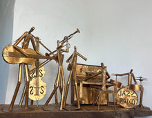 Load image into Gallery viewer, It features abstract, elongated figures of musicians playing various instruments, including a guitar, double bass, trumpet, trombone, saxophone, piano, and drums.