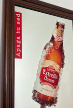 Load image into Gallery viewer, The main image is a unique graphic of an ice-encrusted Estrella Damm bottle held like a popsicle or ice lolly by a hand.