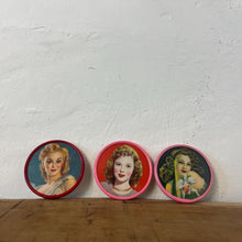Load image into Gallery viewer, Beautiful mid-century vintage compact mirrors or small circular handbag mirrors featuring pin-up style art from the mid-20th century.