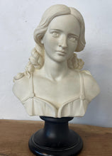 Load image into Gallery viewer, The figure depicts a young woman with wavy hair gathered into ringlets over her shoulders, wearing a draped garment with spaghetti straps and rosette detailing. Her facial expression is serene with downcast eyes.