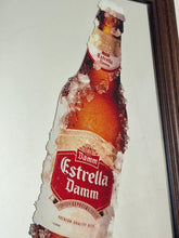 Load image into Gallery viewer, The main image is a unique graphic of an ice-encrusted Estrella Damm bottle held like a popsicle or ice lolly by a hand.