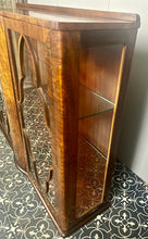 Load image into Gallery viewer, This beautiful piece is a 1930s English Art Deco cocktail cabinet, characterized by its figured walnut veneers and distinctive geometric glazed doors.