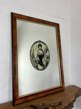 Load image into Gallery viewer, The mirror depicts a glamorous Victorian lady in an oval design with a noir effect, and it includes intricate details and a provocative finish. The walnut frame is of high quality and dates back to the 1920s.