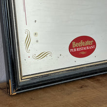 Load image into Gallery viewer, It features an oval logo of the famous pub branding in a matt red, an intricate Victorian-style gold border, and a darker wooden frame.