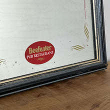Load image into Gallery viewer, It features an oval logo of the famous pub branding in a matt red, an intricate Victorian-style gold border, and a darker wooden frame.