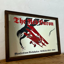 Load image into Gallery viewer, Vintage Red Baron plane mirror featuring vivid picture of the plane in bright colours with a battle scene over the mirror and bold font describing the pilot name and the dates, more historical detail about the piece further down.