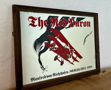 Load image into Gallery viewer, Vintage Red Baron plane mirror featuring vivid picture of the plane in bright colours with a battle scene over the mirror and bold font describing the pilot name and the dates, more historical detail about the piece further down.