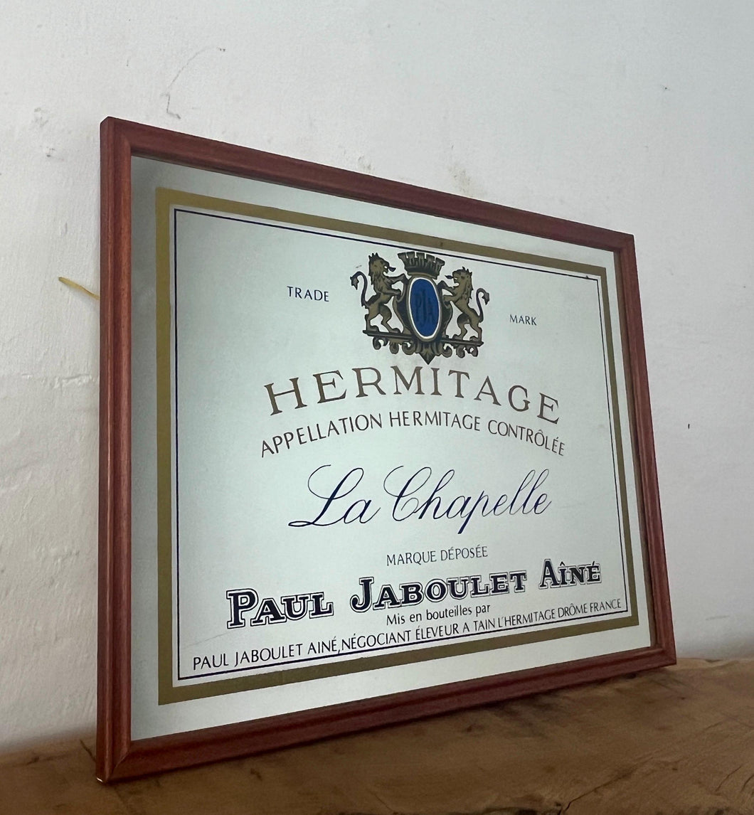 Paul Jaboulet Aine La Chapelle wine advertising mirror in an elegant design of the famous French exclusive wine producer with multiple classy fonts on the branding with the intricate gold motif logo and a sleek gold and black border.