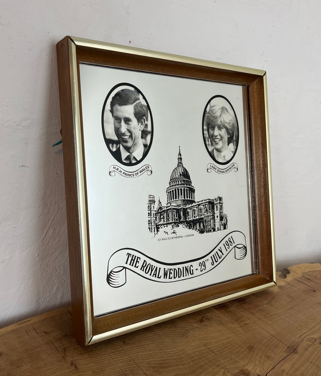 Vibrant mirror featuring the wedding of Charles and Diana on the 29th of July 1981 with a portrait of the couple and intricate picture of St Pauls and the fonts in a banner design.