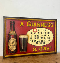 Load image into Gallery viewer, Stunning Guinness vintage calendar plaque showing detailed model of the foreign extra bottle and glass with marvellous matt tones with an aged label, the piece design in a intricate detailed finish, hand painted fonts.
