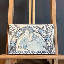 Load image into Gallery viewer, This vintage art nouveau wooden wall plaque, with a blue effect, is a unique piece of art. It features an elegant lady wearing an attractive headdress, her hair tied up, and a selection of glamorous clothing.
