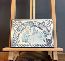 Load image into Gallery viewer, This vintage art nouveau wooden wall plaque, with a blue effect, is a unique piece of art. It features an elegant lady wearing an attractive headdress, her hair tied up, and a selection of glamorous clothing.
