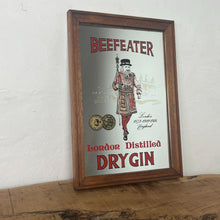 Load image into Gallery viewer, Vintage Beefeater London dry gin mirror, an advertising collectable for wines and spirits. The stunning design features the famous London gin brand in vivid red fonts, a vibrant gold background, and a picture of the familiar logo
