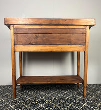 Load image into Gallery viewer, Excellent pitch pine clerk desk with raised back and sloped writing surface over a single fall-front cupboard with key, raised on square supports united by under-tier two plank pine shelf.
