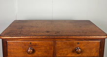 Load image into Gallery viewer, Good quality large antique Victorian mahogany chest of drawers with curved corners, turned bun handles, and a part missing underneath one handle. The bottom drawer is deep and has the plinth attached.
