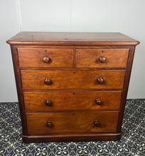 Load image into Gallery viewer, Good quality large antique Victorian mahogany chest of drawers with curved corners, turned bun handles, and a part missing underneath one handle. The bottom drawer is deep and has the plinth attached.
