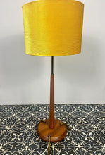 Load image into Gallery viewer, Vintage Scandinavian designer Teak Floor Lamp. This stunning teak floor lamp features a circular base with stylish brass details paired with a mustard fabric lamp shade. It is perfect as an additional light in your living room or workspace.
