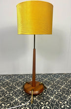 Load image into Gallery viewer, Vintage Scandinavian designer Teak Floor Lamp. This stunning teak floor lamp features a circular base with stylish brass details paired with a mustard fabric lamp shade. It is perfect as an additional light in your living room or workspace.
