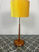 Load image into Gallery viewer, Vintage Scandinavian designer Teak Floor Lamp. This stunning teak floor lamp features a circular base with stylish brass details paired with a mustard fabric lamp shade. It is perfect as an additional light in your living room or workspace.
